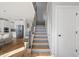 Inviting entryway showcasing wood floors and stairs leading to a modern, stylish kitchen at 204 Woodstaff Ave, Wake Forest, NC 27587