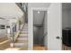 Bright entryway features wood stairs, gray accents, and a glimpse into the modern kitchen at 204 Woodstaff Ave, Wake Forest, NC 27587