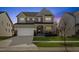 Charming two-story home featuring a well-manicured lawn and a welcoming front porch at dusk at 204 Woodstaff Ave, Wake Forest, NC 27587