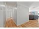 Well-lit hallway with hardwood floors and neutral walls leads to a cozy, inviting living area at 204 Woodstaff Ave, Wake Forest, NC 27587