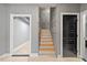 Inviting hallway with paneled walls, hardwood stairs, and access to multiple rooms at 204 Woodstaff Ave, Wake Forest, NC 27587