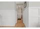 Clean hallway with light hardwood floors and paneled wainscoting with neutral paint at 204 Woodstaff Ave, Wake Forest, NC 27587