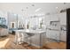 Sunlit kitchen with island seating, hardwood floors, stainless appliances, and view to living room at 204 Woodstaff Ave, Wake Forest, NC 27587