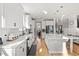 Bright kitchen showcases island with seating, stainless appliances, and hardwood floors leading to stairs at 204 Woodstaff Ave, Wake Forest, NC 27587
