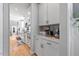 Bright kitchen boasts white cabinetry, sleek countertops, and modern appliances; hardwood floors lead to living area at 204 Woodstaff Ave, Wake Forest, NC 27587