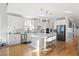 Open kitchen features an island with seating, stainless steel appliances, and hardwood floors at 204 Woodstaff Ave, Wake Forest, NC 27587