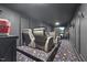 Home theater room with tiered seating, projector screen, and unique galaxy-themed carpet at 204 Woodstaff Ave, Wake Forest, NC 27587