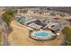 Community clubhouse with a pool, tennis courts, and outdoor seating area overlooking the lush landscape at 2109 Flycatcher Ln, Fuquay Varina, NC 27526