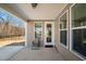 Cozy covered back porch with a single chair, offering a view of the yard and surrounding trees at 2109 Flycatcher Ln, Fuquay Varina, NC 27526