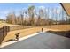 Backyard featuring an empty concrete patio with decorative urns and black metal fence at 2109 Flycatcher Ln, Fuquay Varina, NC 27526