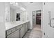 Bright bathroom featuring a double vanity, large mirror, tiled floors, and an adjacent walk-in closet at 2109 Flycatcher Ln, Fuquay Varina, NC 27526