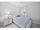Cozy bedroom with a white spindle bed, ceiling fan, bedside table, and window with natural light at 2109 Flycatcher Ln, Fuquay Varina, NC 27526