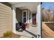 Charming covered front porch featuring white columns, a bench and a dark red door at 2109 Flycatcher Ln, Fuquay Varina, NC 27526