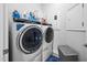 Modern laundry room featuring a front-load washer and dryer, ample storage, and a blue rug at 2109 Flycatcher Ln, Fuquay Varina, NC 27526