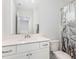 Bright bathroom with a white vanity, large mirror, and decorative shower curtain at 234 Palmetto Tree Way, Knightdale, NC 27545