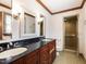 Bathroom featuring dual sinks, granite countertops, and a walk-in shower at 241 Beachers Brook Ln, Cary, NC 27511