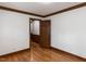 Bedroom featuring hardwood floors, wood trim, and a door leading to the hallway at 241 Beachers Brook Ln, Cary, NC 27511