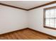 Bright bedroom featuring hardwood floors, wood trim, and a window with blinds at 241 Beachers Brook Ln, Cary, NC 27511