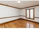 Spacious bedroom featuring hardwood floors, white walls with wood trim, and a window at 241 Beachers Brook Ln, Cary, NC 27511
