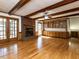 Open living room with a brick fireplace, hardwood floors, and wooden beam ceilings at 241 Beachers Brook Ln, Cary, NC 27511