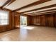 Spacious living room featuring wood-paneled walls, beamed ceilings, and a sliding glass door at 241 Beachers Brook Ln, Cary, NC 27511