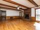 Spacious living room with a brick fireplace, hardwood floors, and wood paneling at 241 Beachers Brook Ln, Cary, NC 27511