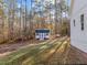 Backyard featuring a shed, a propane tank, and wooded surroundings at 290 Whistlers Cv, Louisburg, NC 27549