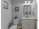 Charming powder room featuring a modern vanity, decorative mirror, and stylish fixtures at 290 Whistlers Cv, Louisburg, NC 27549