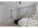 Primary bedroom with adjoining bathroom, dresser and view to wooded area at 290 Whistlers Cv, Louisburg, NC 27549