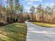 Long driveway leading to a secluded estate with mature trees and landscaping at 290 Whistlers Cv, Louisburg, NC 27549