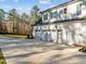 White three-car garage showcasing a wide driveway and well-maintained landscaping at 290 Whistlers Cv, Louisburg, NC 27549
