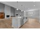 Open-concept kitchen with island seating and stainless steel appliances flows into the living area with fireplace at 290 Whistlers Cv, Louisburg, NC 27549