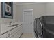 Well-lit laundry room with modern washer and dryer, sink, and ample counter space at 290 Whistlers Cv, Louisburg, NC 27549