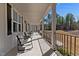 Covered porch with railing and several rocking chairs for relaxing at 290 Whistlers Cv, Louisburg, NC 27549
