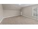 This attic space has carpet, a window, and neutral walls at 307 Sugarberry Ln, Clayton, NC 27527