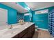 Bright bathroom features a double vanity, large mirror, and turquoise walls at 307 Sugarberry Ln, Clayton, NC 27527