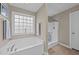 Bright bathroom with a large soaking tub and a separate glass-enclosed shower at 307 Sugarberry Ln, Clayton, NC 27527