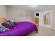 Comfortable bedroom featuring purple bedding, carpet, and a view into the hall at 307 Sugarberry Ln, Clayton, NC 27527