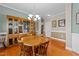 Cozy dining area with a round wooden table, seating for four, a chandelier, and hardwood floors at 307 Sugarberry Ln, Clayton, NC 27527