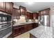 Gourmet kitchen featuring stainless steel appliances, granite countertops, and rich cabinetry at 307 Sugarberry Ln, Clayton, NC 27527