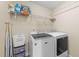 Efficient laundry room with washer, dryer, and ample storage shelving at 307 Sugarberry Ln, Clayton, NC 27527
