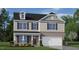 Charming two-story home featuring a brick facade, attached garage, and well-manicured lawn at 31 Red Cedar Way, Fuquay Varina, NC 27526