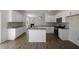 Spacious open-concept kitchen with white cabinets, a center island, and stainless steel appliances at 31 Red Cedar Way, Fuquay Varina, NC 27526