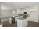 Open-concept kitchen boasts granite counters, white cabinets, stainless appliances, and breakfast bar at 31 Red Cedar Way, Fuquay Varina, NC 27526
