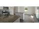 Open-concept kitchen features granite countertops, stainless steel appliances, an island, and hardwood floors at 31 Red Cedar Way, Fuquay Varina, NC 27526