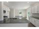 Bright kitchen featuring white cabinets, granite countertops, an island, and stainless steel appliances at 31 Red Cedar Way, Fuquay Varina, NC 27526