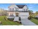 Stately two-story white brick home with a covered front porch and a two-car garage at 3176 Armeria Dr, Apex, NC 27502