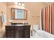 Traditional bathroom features a vanity with dark cabinets and a shower with a colorful striped curtain at 3324 Thomas Rd, Raleigh, NC 27607