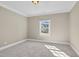 Cozy bedroom featuring neutral carpeting, crown molding, and a bright window that provides natural light at 3324 Thomas Rd, Raleigh, NC 27607