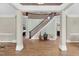 Spacious foyer with elegant staircase, hardwood floors, and decorative columns at 3324 Thomas Rd, Raleigh, NC 27607